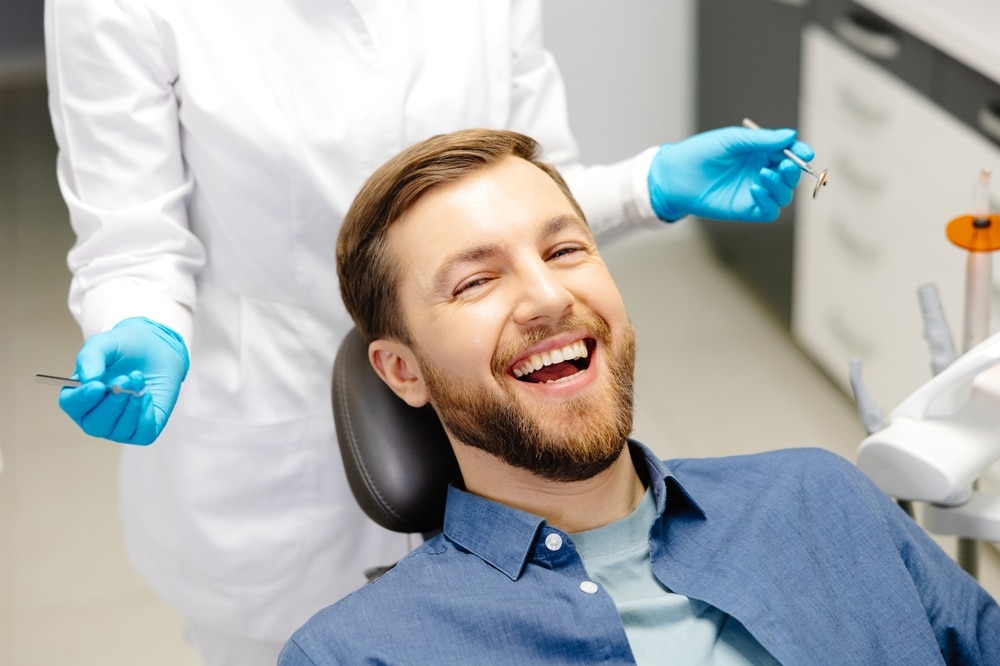 Bearded white man is smiling and relaxed at the dentistry with help from oral sedation.